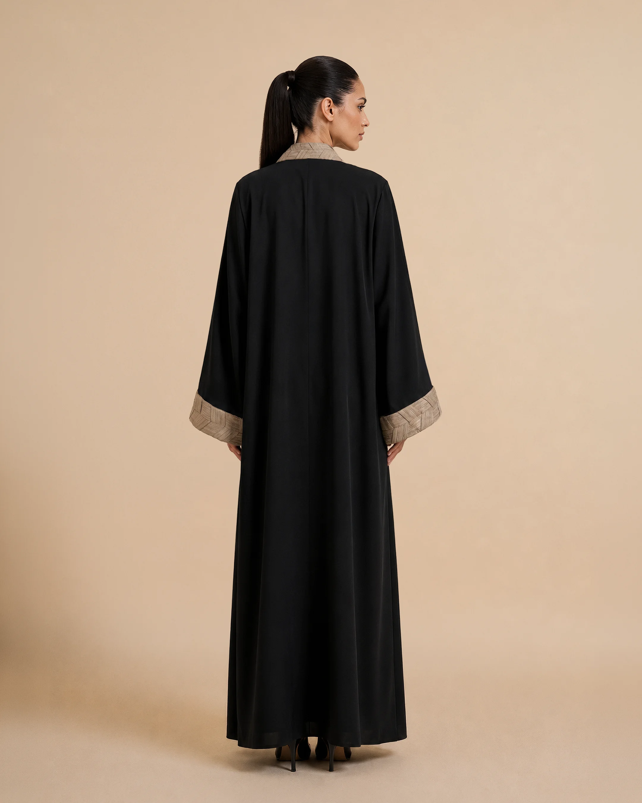 Belgravia Abaya luxury abaya in Black, back view, trim inspired by traditional Khous weaving, Emirati heritage and Abu Dhabi culture. Bint Saeed Abu Dhabi, UAE.