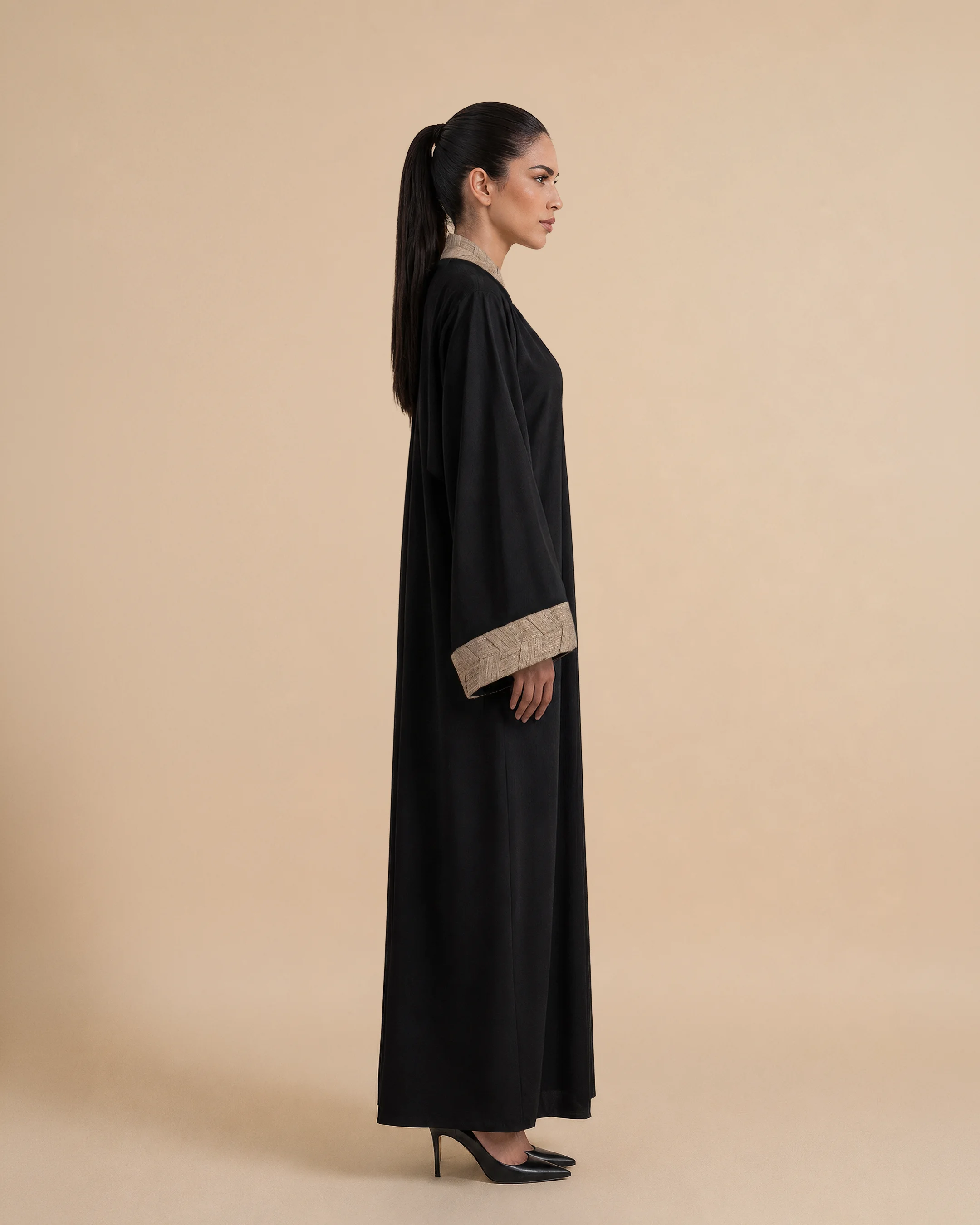 Belgravia Abaya luxury abaya in Black, side view, trim inspired by traditional Khous weaving, Emirati heritage and Abu Dhabi culture. Bint Saeed Abu Dhabi, UAE.