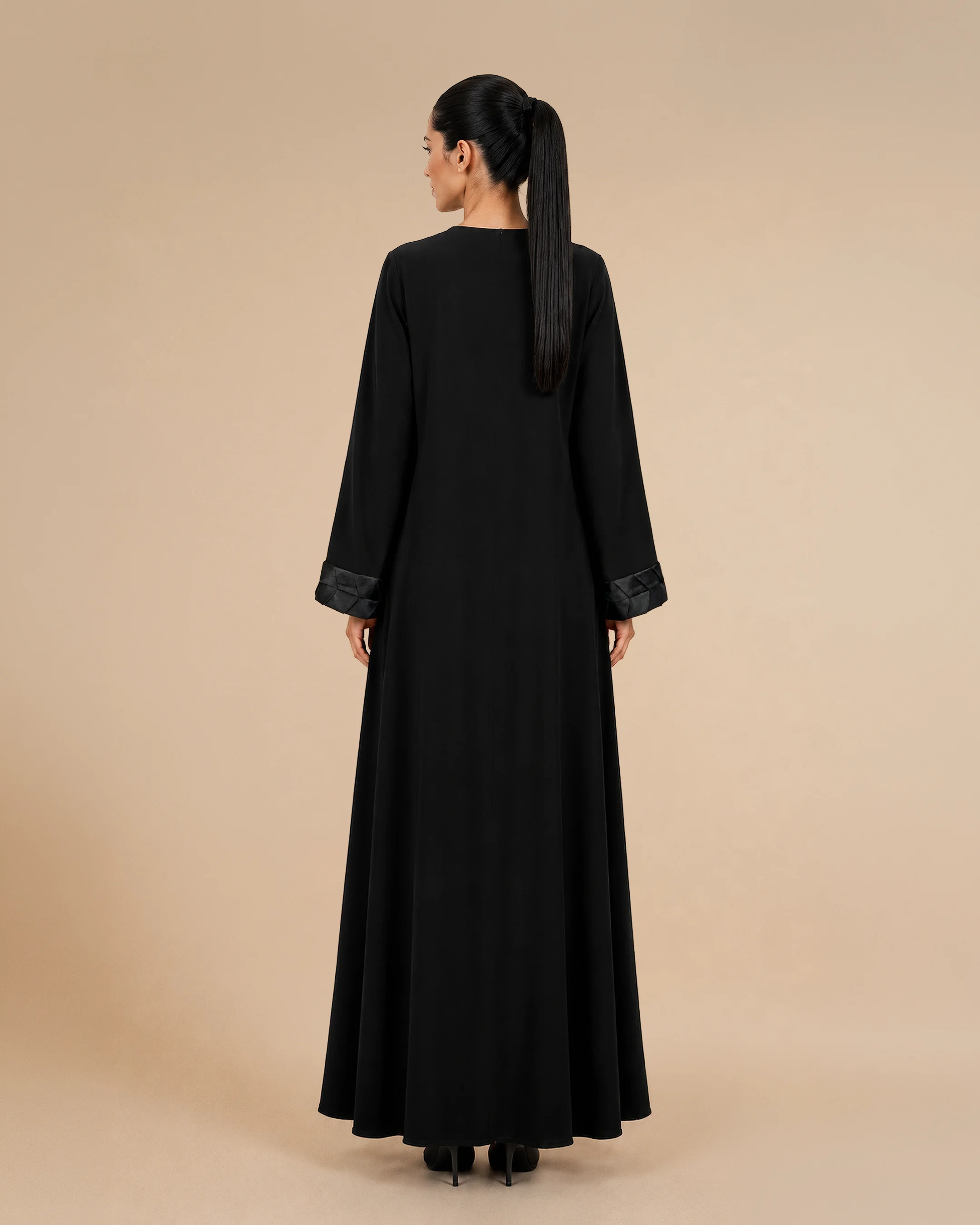 Kensington Abaya luxury abaya in Black, back view, trim inspired by traditional Khous weaving, Emirati heritage and Abu Dhabi culture. Bint Saeed Abu Dhabi, UAE.
