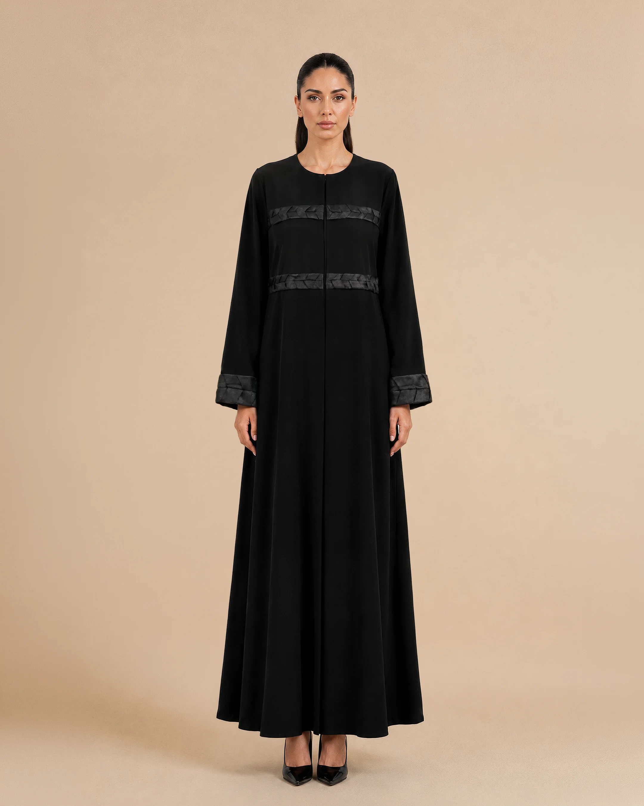 Kensington Abaya luxury abaya in Black, front view, trim inspired by traditional Khous weaving, Emirati heritage and Abu Dhabi culture. Bint Saeed Abu Dhabi, UAE.