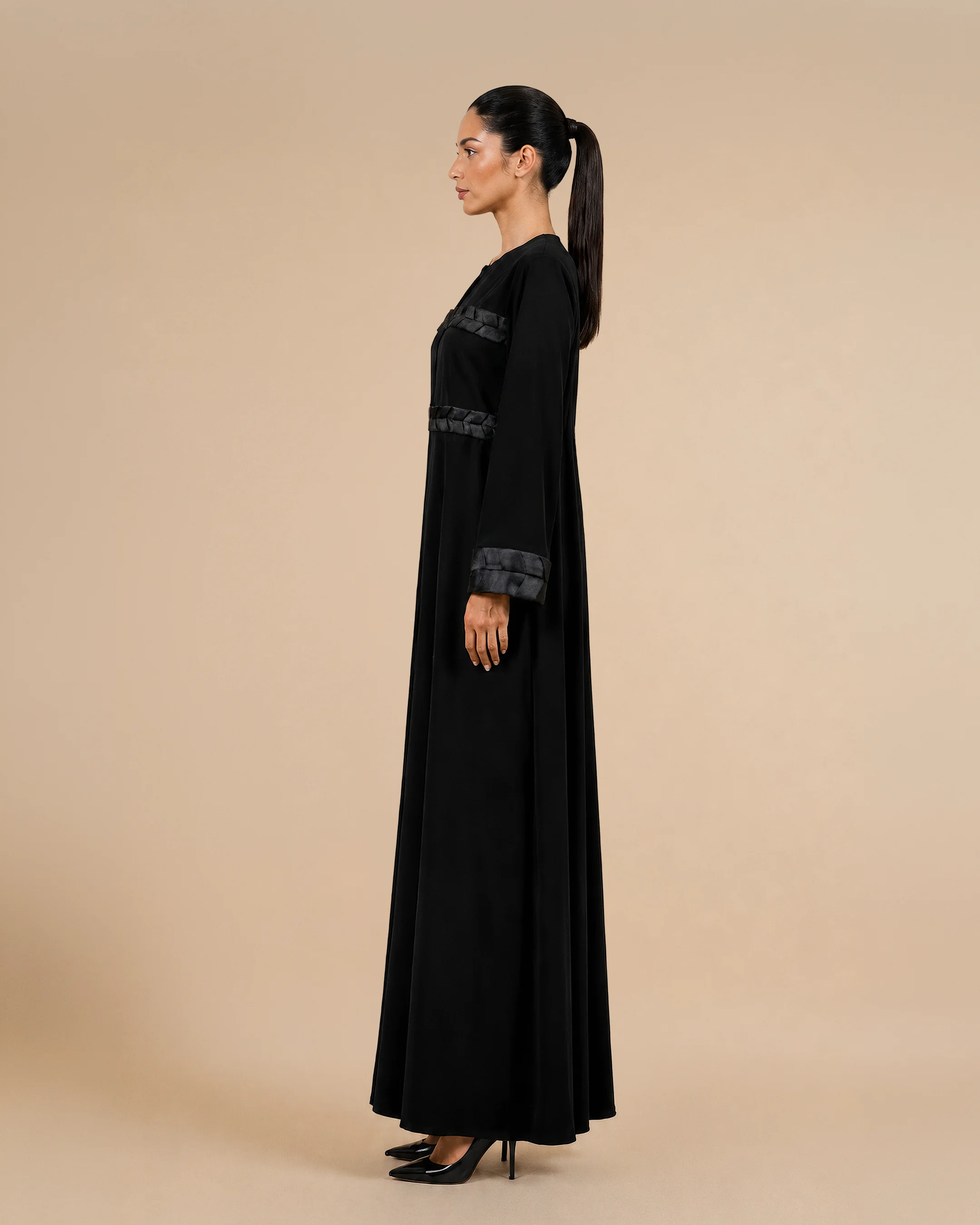 Kensington Abaya luxury abaya in Black, side view, trim inspired by traditional Khous weaving, Emirati heritage and Abu Dhabi culture. Bint Saeed Abu Dhabi, UAE.