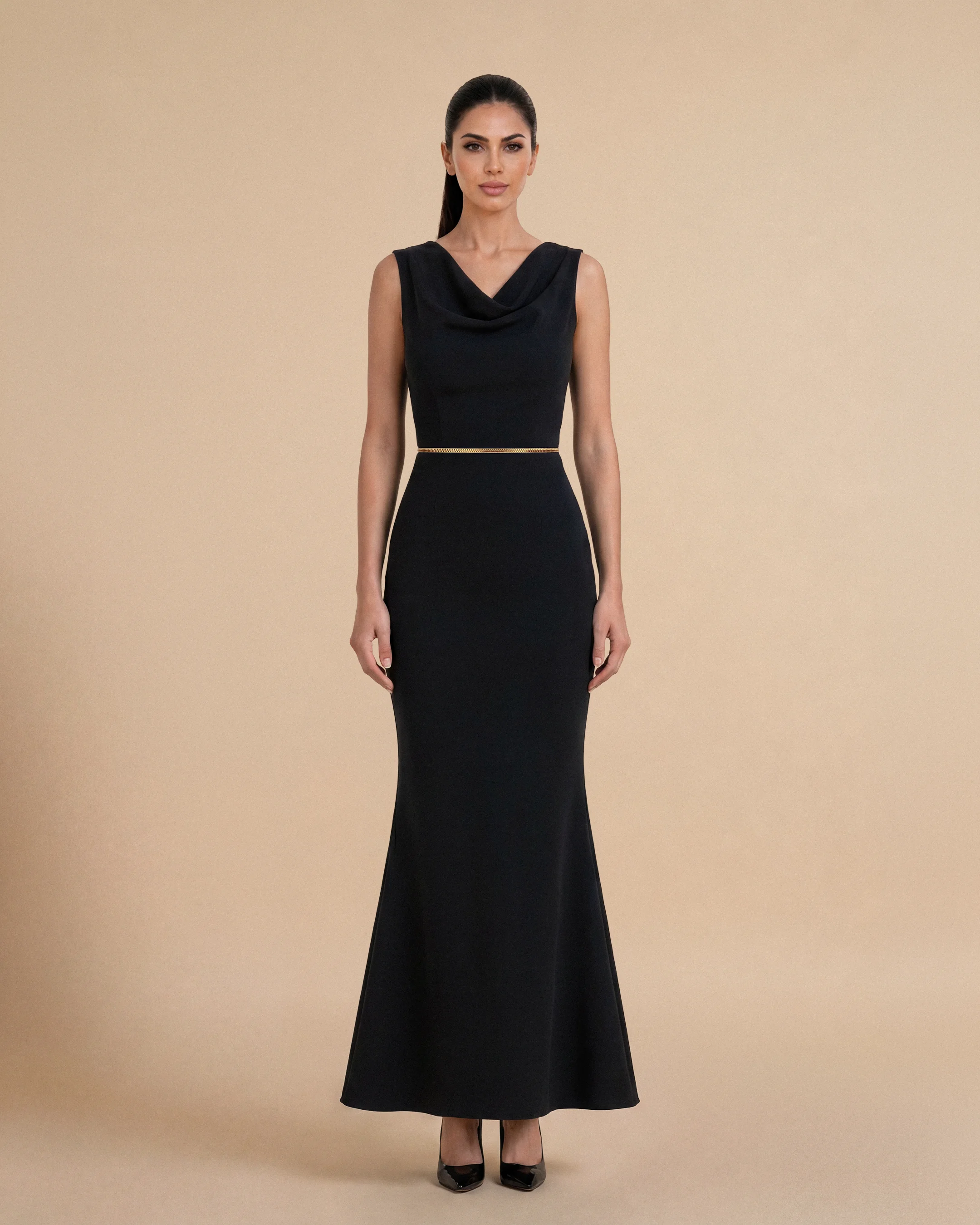 Bint Saeed Hampstead Dress Hitam pekat, tampak depan. Gaun maxi tailored dengan garis leher drape elegan, hem flare lembut, dan trim Al Talli tenun signature di pinggang. Gaun maxi krepe premium berlapis penuh dengan garis leher drape elegan, siluet lembut terbentuk, saku sisi tersembunyi, dan trim Al Talli tenun signature di pinggang — warisan Emirati diakui UNESCO, ditafsir ulang di Abu Dhabi. Dipakai sendiri atau di bawah abaya. Dibuat di Abu Dhabi, UEA. Pengiriman dunia. Bint Saeed Abu Dhabi, Uni Emirat Arab.