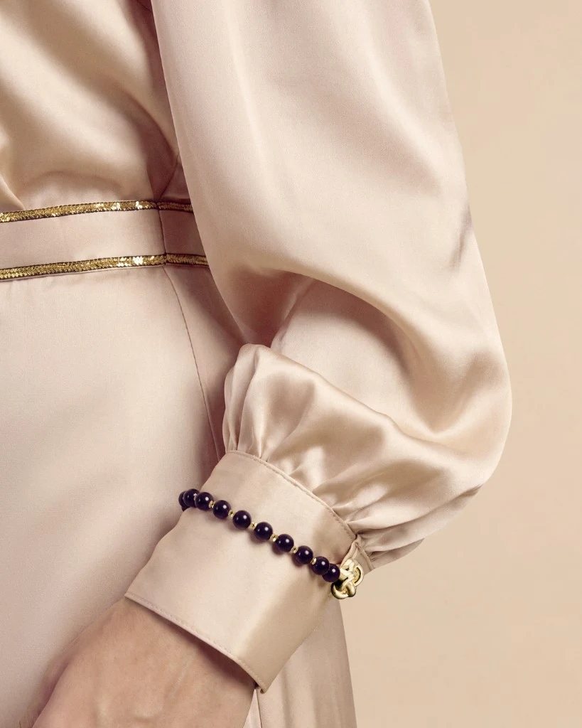 منظر lifestyle ثانٍ لطقم Grosvenor باللون Champagne Cream يُظهر حركة الساتان عند حاشية التنورة ونسب المساء المنسّقة. Bint Saeed أبوظبي، الإمارات العربية المتحدة.