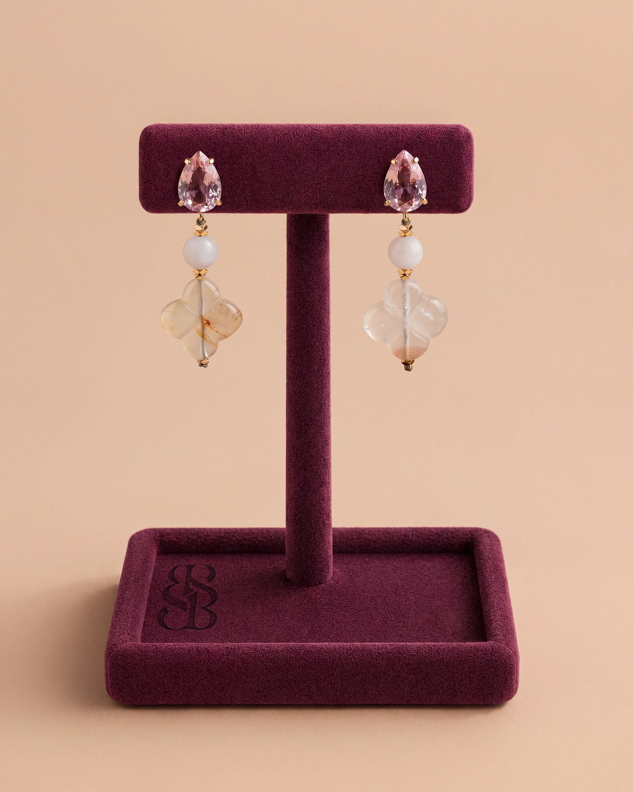 Al Quaa Earrings - Rose Quartz by Bint Saeed: genuine Rose Quartz gemstones, hand-carved Carnelian Al Ain Rosette, faceted gold-plated Hematite beads and a pear-cut pink zirconia stud in 18k gold-plated brass. Luxury hand-assembled drop earrings, drop 4 cm. Made in Abu Dhabi, United Arab Emirates. Worldwide shipping. Bint Saeed Abu Dhabi, United Arab Emirates.
