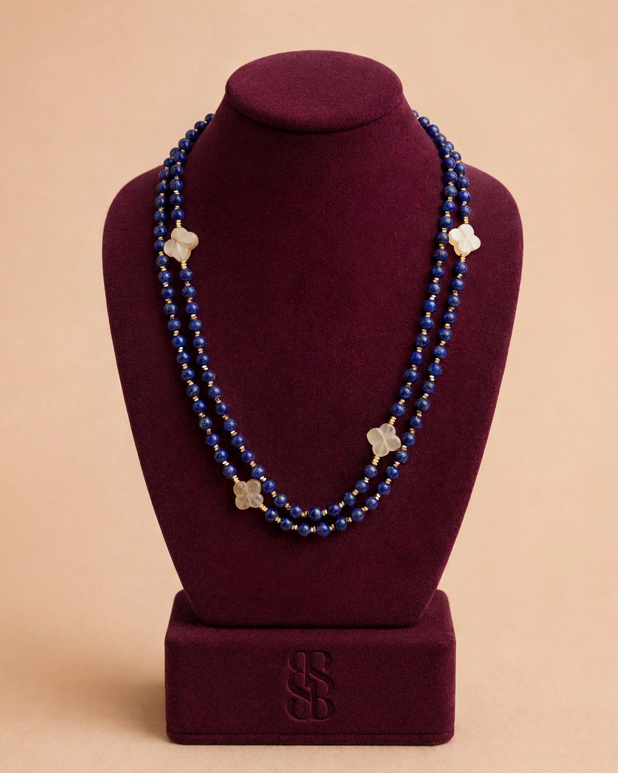 Kalung Al Ain Oasis — Lapis lazuli — manik lapis biru royal dalam dengan Rosette Al Ain karnelian dan kait signature, buatan tangan Bint Saeed Abu Dhabi. Bint Saeed Abu Dhabi, Uni Emirat Arab.