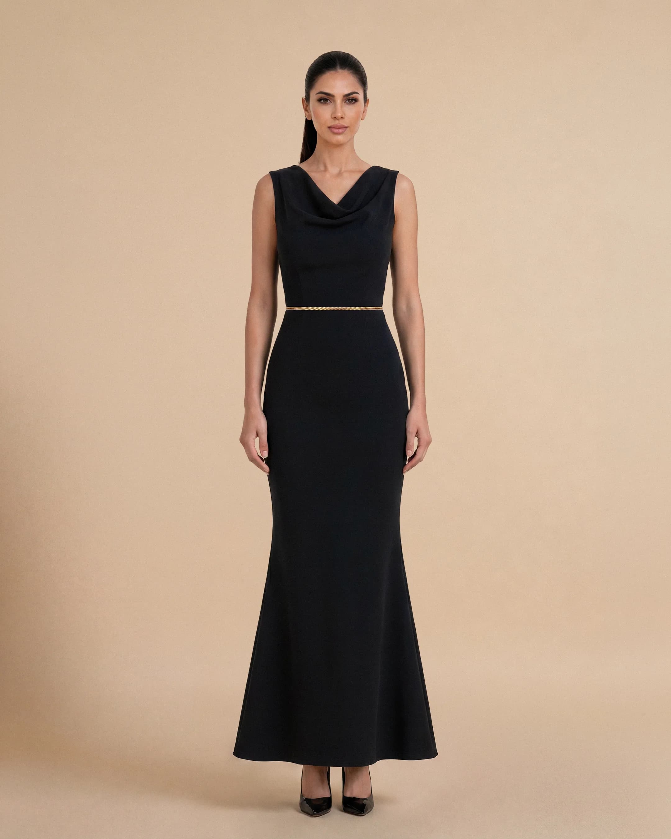 Bint Saeed Hampstead Dress Hitam pekat, tampak depan. Gaun maxi tailored dengan garis leher drape elegan, hem flare lembut, dan trim Al Talli tenun signature di pinggang. Gaun maxi krepe premium berlapis penuh dengan garis leher drape elegan, siluet lembut terbentuk, saku sisi tersembunyi, dan trim Al Talli tenun signature di pinggang — warisan Emirati diakui UNESCO, ditafsir ulang di Abu Dhabi. Dipakai sendiri atau di bawah abaya. Dibuat di Abu Dhabi, UEA. Pengiriman dunia. Bint Saeed Abu Dhabi, Uni Emirat Arab.