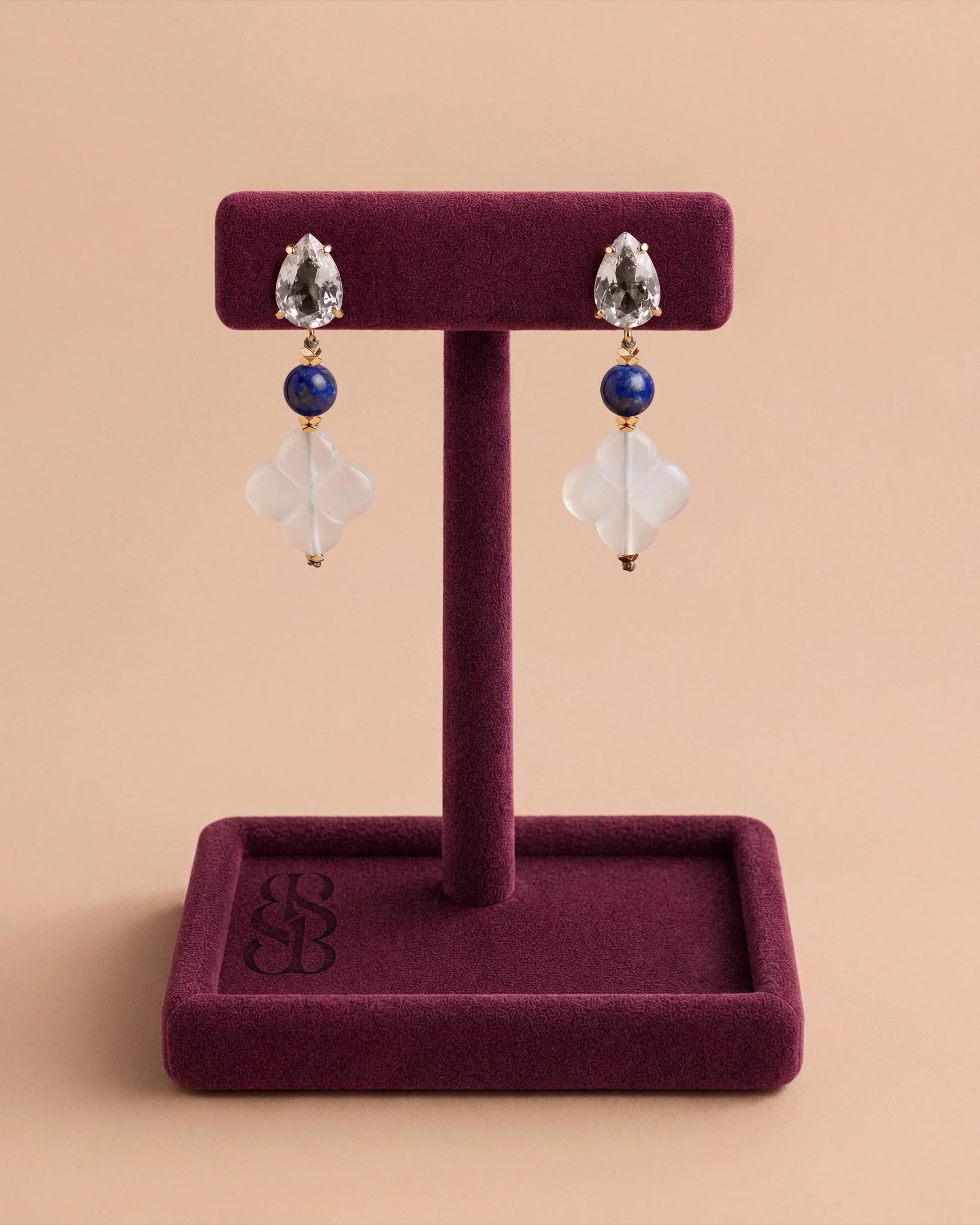 Anting Al Quaa — Lapis lazuli — lapis biru royal dengan inklusi pirit, Rosette Al Ain karnelian dan stud zirconia bening potongan pir, anting drop mewah Bint Saeed Abu Dhabi. Bint Saeed Abu Dhabi, Uni Emirat Arab.