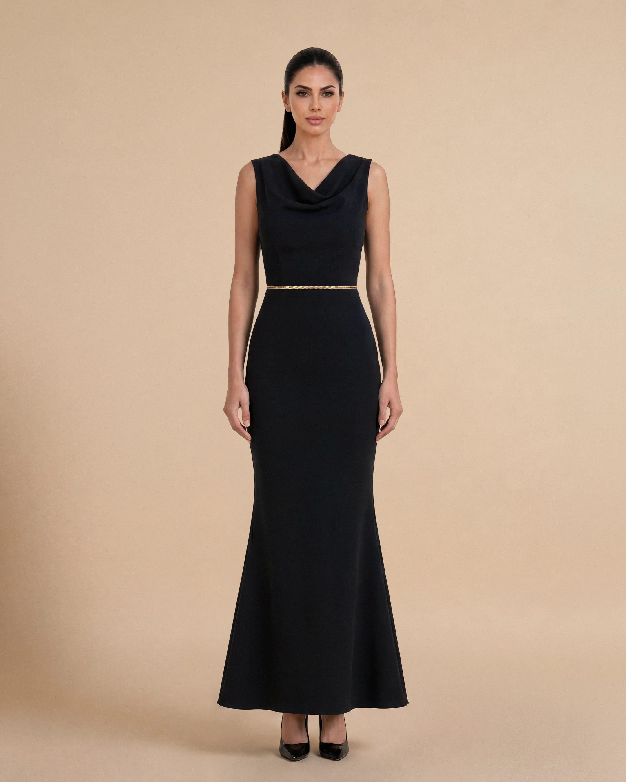 Bint Saeed Hampstead Dress Hitam pekat, tampak depan. Gaun maxi tailored dengan garis leher drape elegan, hem flare lembut, dan trim Al Talli tenun signature di pinggang. Gaun maxi krepe premium berlapis penuh dengan garis leher drape elegan, siluet lembut terbentuk, saku sisi tersembunyi, dan trim Al Talli tenun signature di pinggang — warisan Emirati diakui UNESCO, ditafsir ulang di Abu Dhabi. Dipakai sendiri atau di bawah abaya. Dibuat di Abu Dhabi, UEA. Pengiriman dunia. Bint Saeed Abu Dhabi, Uni Emirat Arab.
