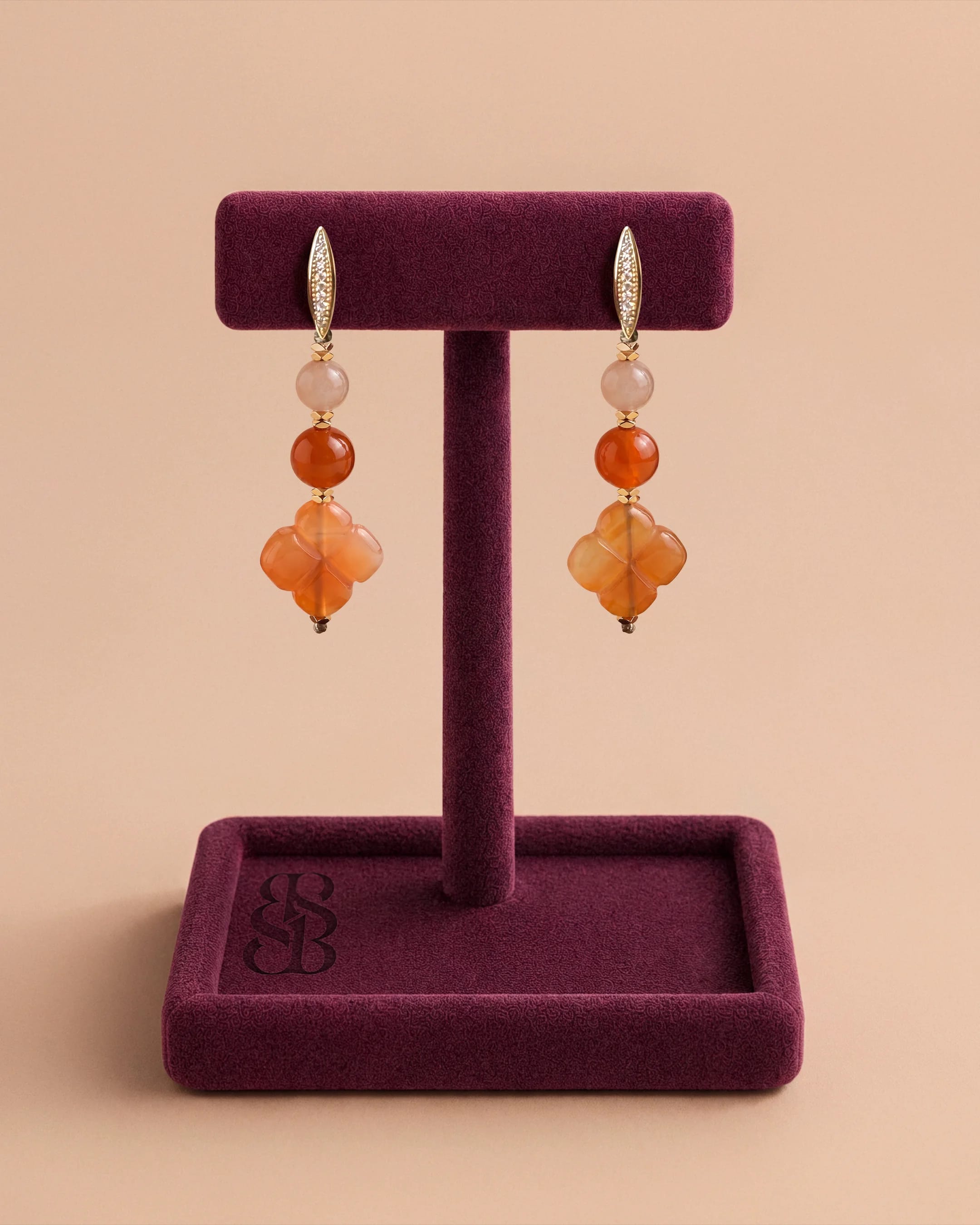 Al Ain Oasis Earrings - Orange Jade by Bint Saeed: genuine Orange Coloured Jade and Sunstone gemstones, hand-carved Carnelian Al Ain Rosette, faceted gold-plated Hematite and pavé zirconia leverback clasp in 14k gold-plated nickel-free copper. Luxury hand-assembled drop earrings, drop 5.5 cm. Made in Abu Dhabi, United Arab Emirates. Worldwide shipping. Bint Saeed Abu Dhabi, United Arab Emirates.