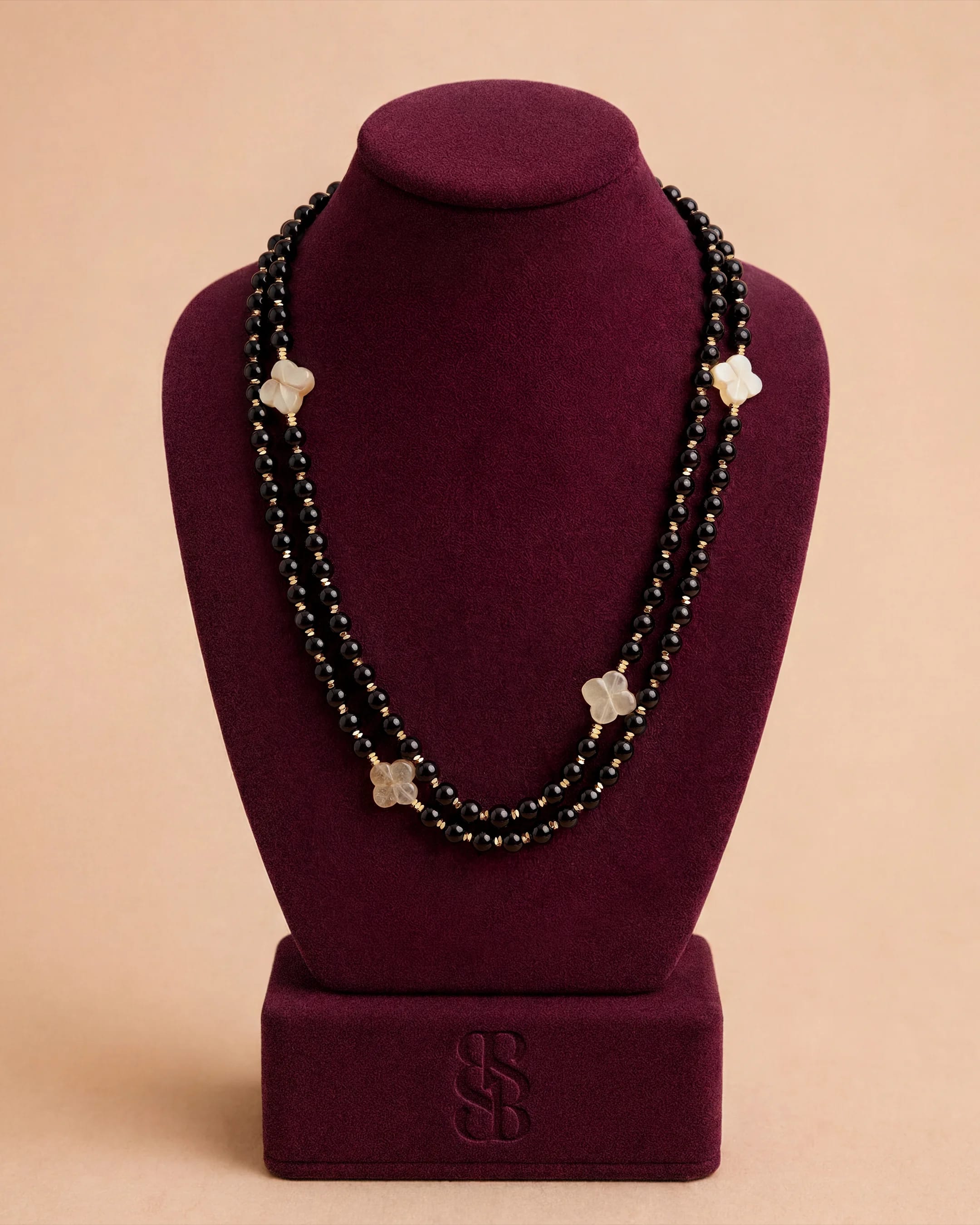 Al Ain Oasis Necklace - Onyx by Bint Saeed: hand-strung polished black onyx beads, Carnelian Al Ain Rosette and refined 18K gold-plated signature clasp — luxury onyx bead necklace, handcrafted in Abu Dhabi, United Arab Emirates. Worldwide shipping. Bint Saeed Abu Dhabi, United Arab Emirates.