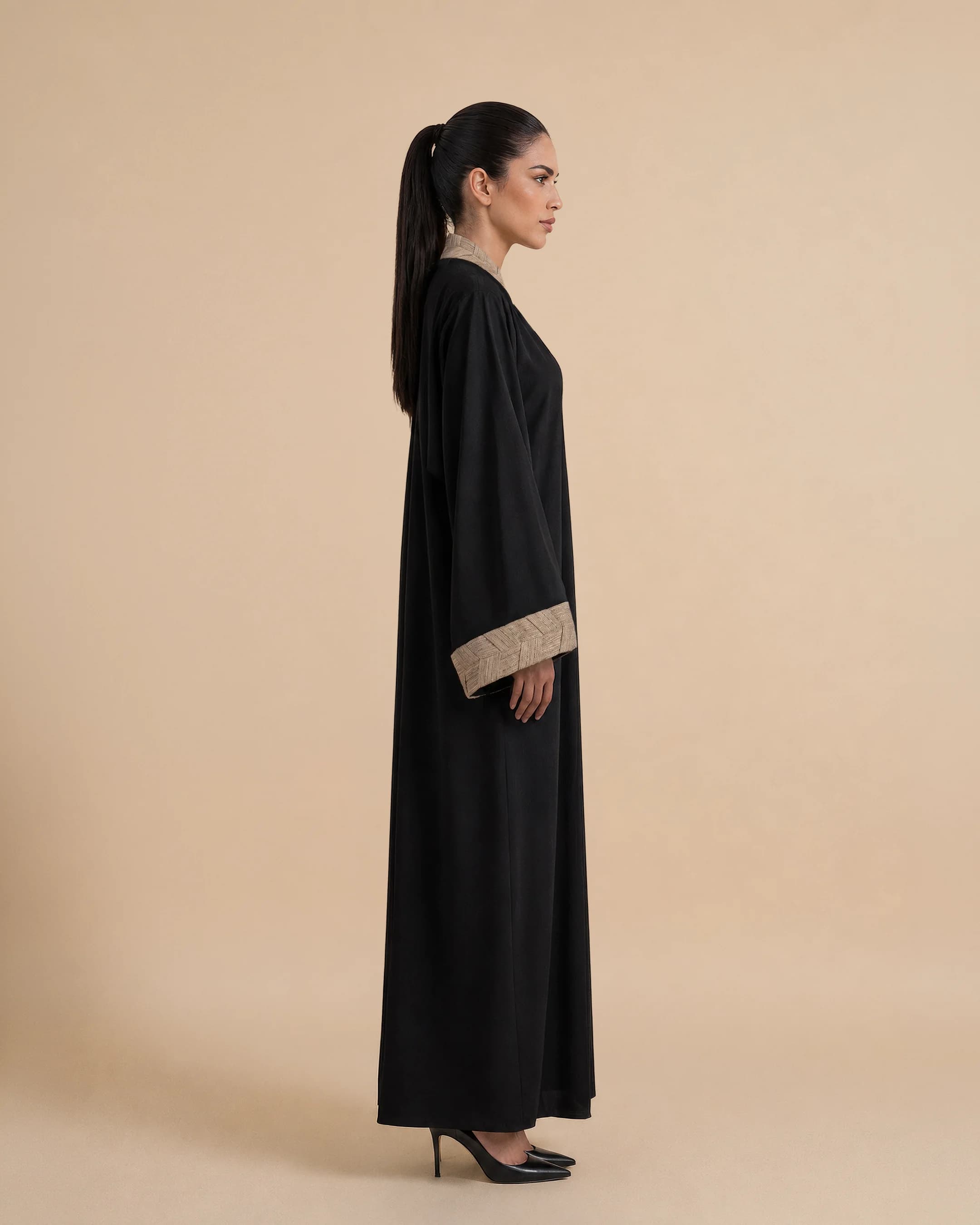 Belgravia Abaya luxury abaya in Black, side view, trim inspired by traditional Khous weaving, Emirati heritage and Abu Dhabi culture. Bint Saeed Abu Dhabi, UAE.