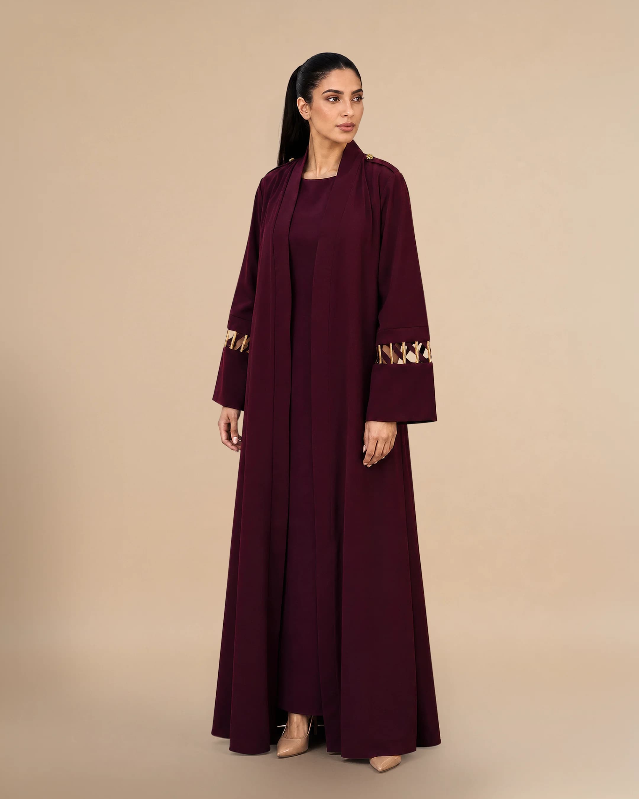 Covent Garden Abaya luxury abaya in Burgundy, side view, traditional Al Talli trim celebrating Emirati heritage and Abu Dhabi culture. Bint Saeed Abu Dhabi, UAE.