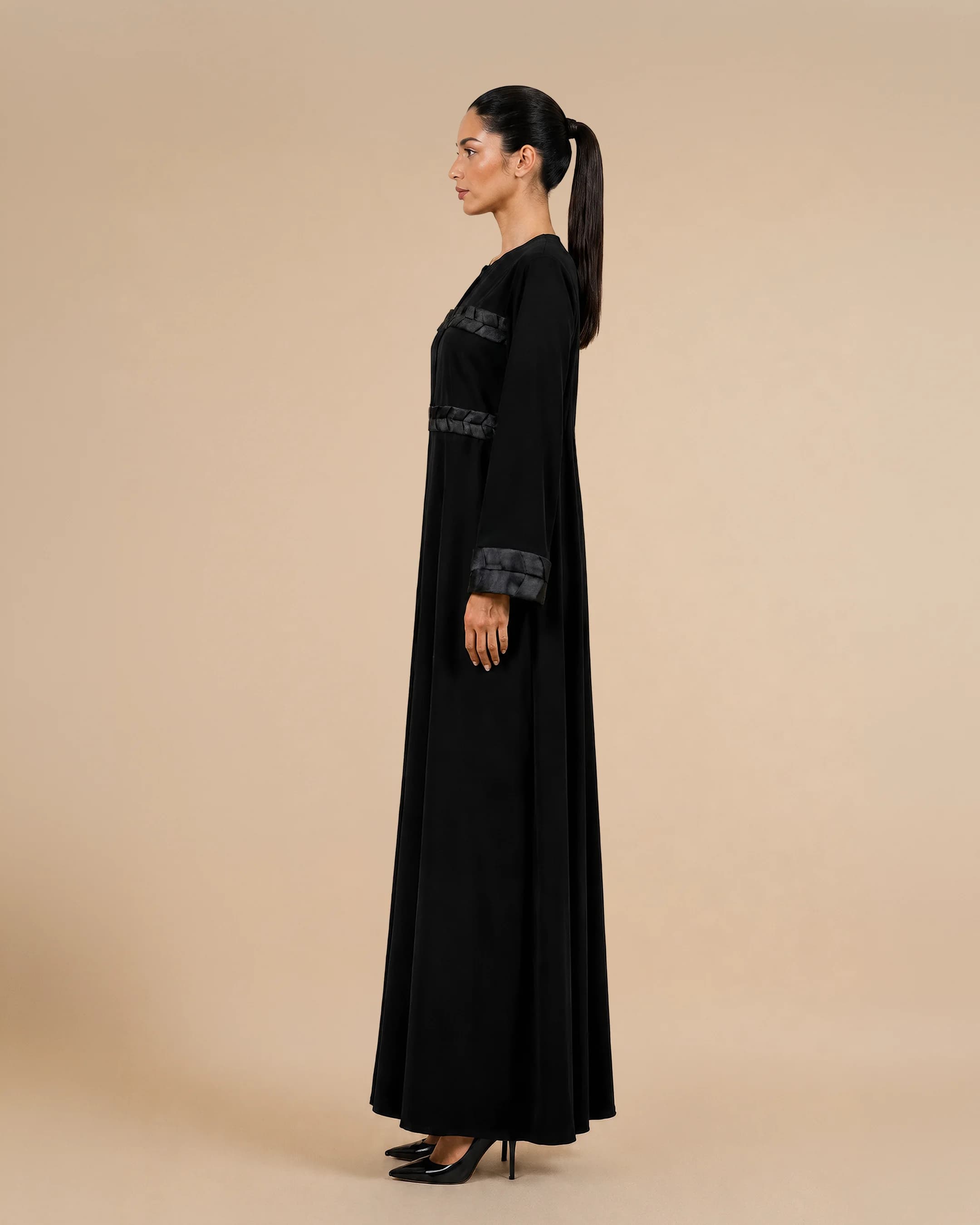Kensington Abaya luxury abaya in Black, side view, trim inspired by traditional Khous weaving, Emirati heritage and Abu Dhabi culture. Bint Saeed Abu Dhabi, UAE.