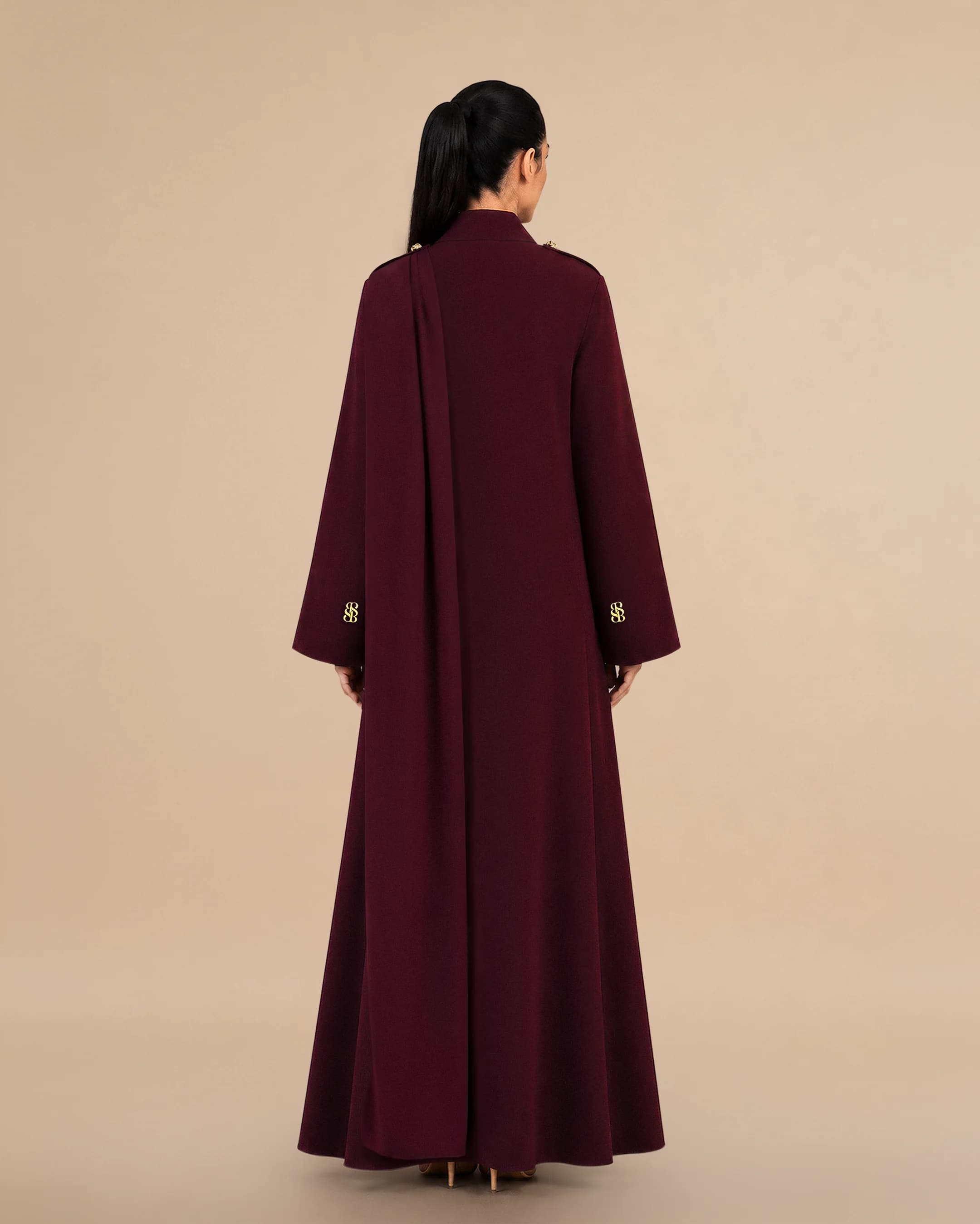 Pandangan belakang Bint Saeed Park Lane Abaya Dark Maroon menyerlahkan siluet A-line anggun, jatuhan mengalir penuh, skarf bahu bersepadu, dan jahitan seni bina bersih. Abaya pereka mewah Bint Saeed Abu Dhabi, UAE — fesyen sopan untuk diplomat, eksekutif, majlis kedutaan, mesyuarat perniagaan, dan almari antarabangsa di London, Paris, Riyadh, Doha, dan seluruh dunia. Dihasilkan di Abu Dhabi. Penghantaran seluruh dunia. Bint Saeed Abu Dhabi, Emiriah Arab Bersatu.