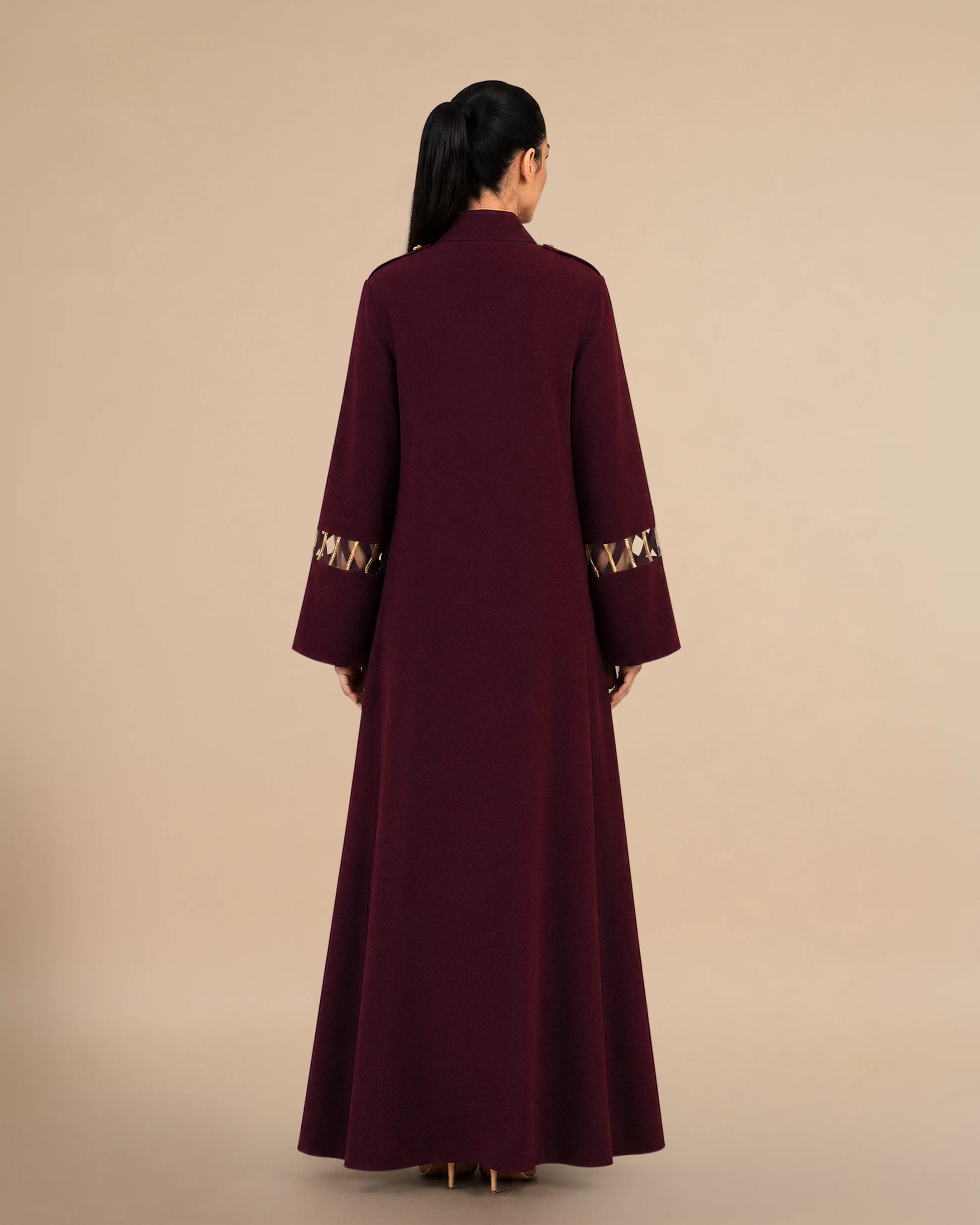 Tampak belakang Bint Saeed Covent Garden Al Talli Abaya Burgundy menonjolkan siluet A-line elegan, drape mengalir penuh, dan tailoring desainer kontemporer yang merayakan kerajinan warisan Al Talli Emirati UNESCO. Abaya mewah premium dirancang di Abu Dhabi untuk UEA, GCC, dan busana modest global. Dibuat di Abu Dhabi, UEA. Pengiriman dunia. Bint Saeed Abu Dhabi, Uni Emirat Arab.