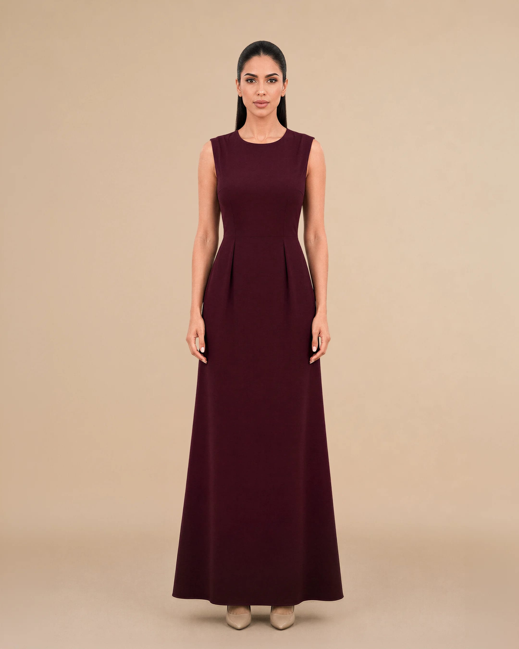 Covent Garden Long Dress in Burgundy, tampak depan — a formal, classy, elegant and simple terstruktur gaun maxi colour variant oleh Bint Saeed, an Emirati contemporary brand from Abu Dhabi, Uni Emirat Arab. Refined long dress with a fitted maxi silhouette, clean round neckline, and concealed back zip. Bint Saeed Abu Dhabi, Uni Emirat Arab.