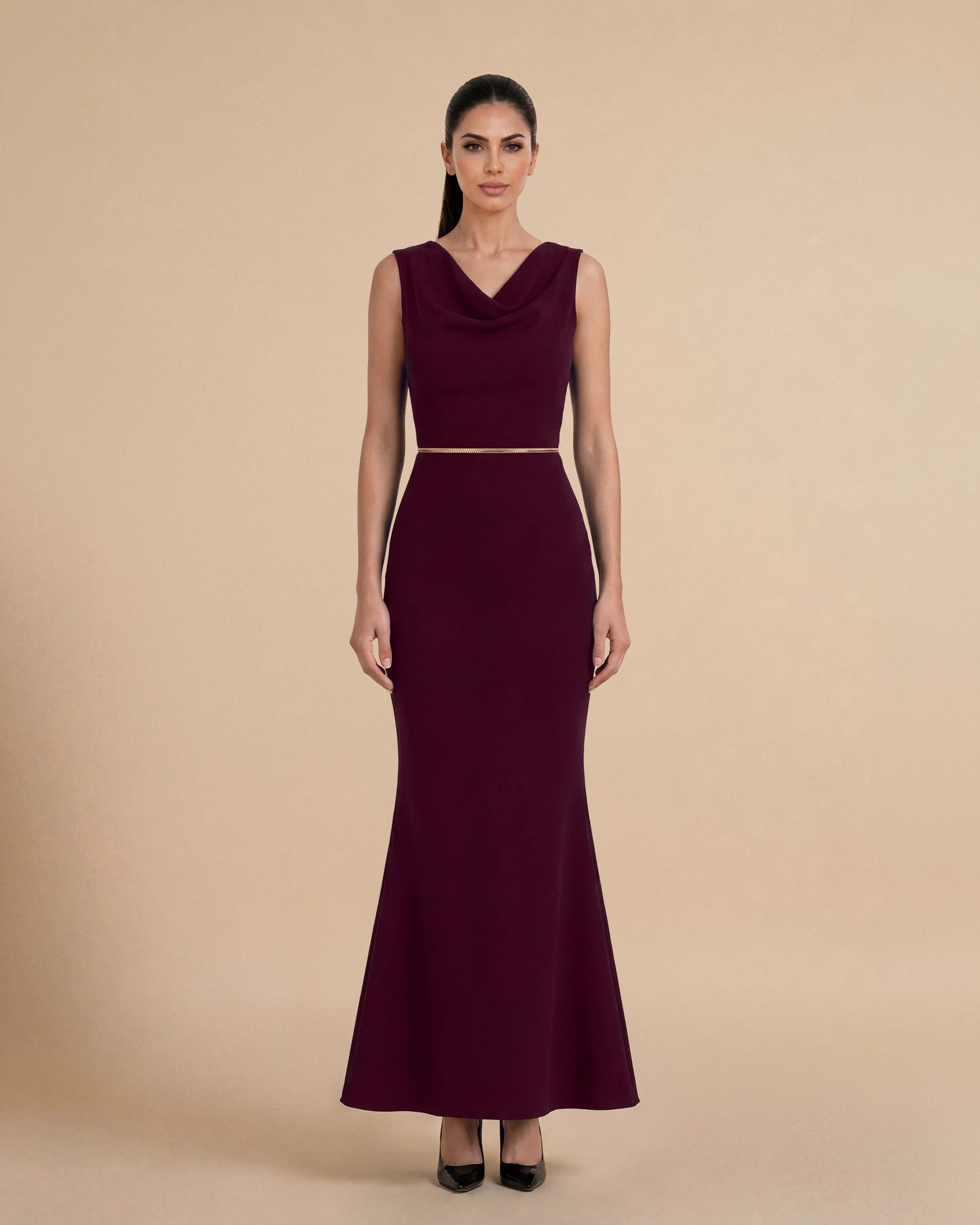 Bint Saeed Hampstead Dress Burgundy, tampak depan. Gaun maxi tailored dengan garis leher drape elegan, hem flare lembut, dan trim Al Talli tenun signature di pinggang. Gaun maxi krepe premium berlapis penuh dengan garis leher drape elegan, siluet lembut terbentuk, saku sisi tersembunyi, dan trim Al Talli tenun signature di pinggang — warisan Emirati diakui UNESCO, ditafsir ulang di Abu Dhabi. Dipakai sendiri atau di bawah abaya. Dibuat di Abu Dhabi, UEA. Pengiriman dunia. Bint Saeed Abu Dhabi, Uni Emirat Arab.