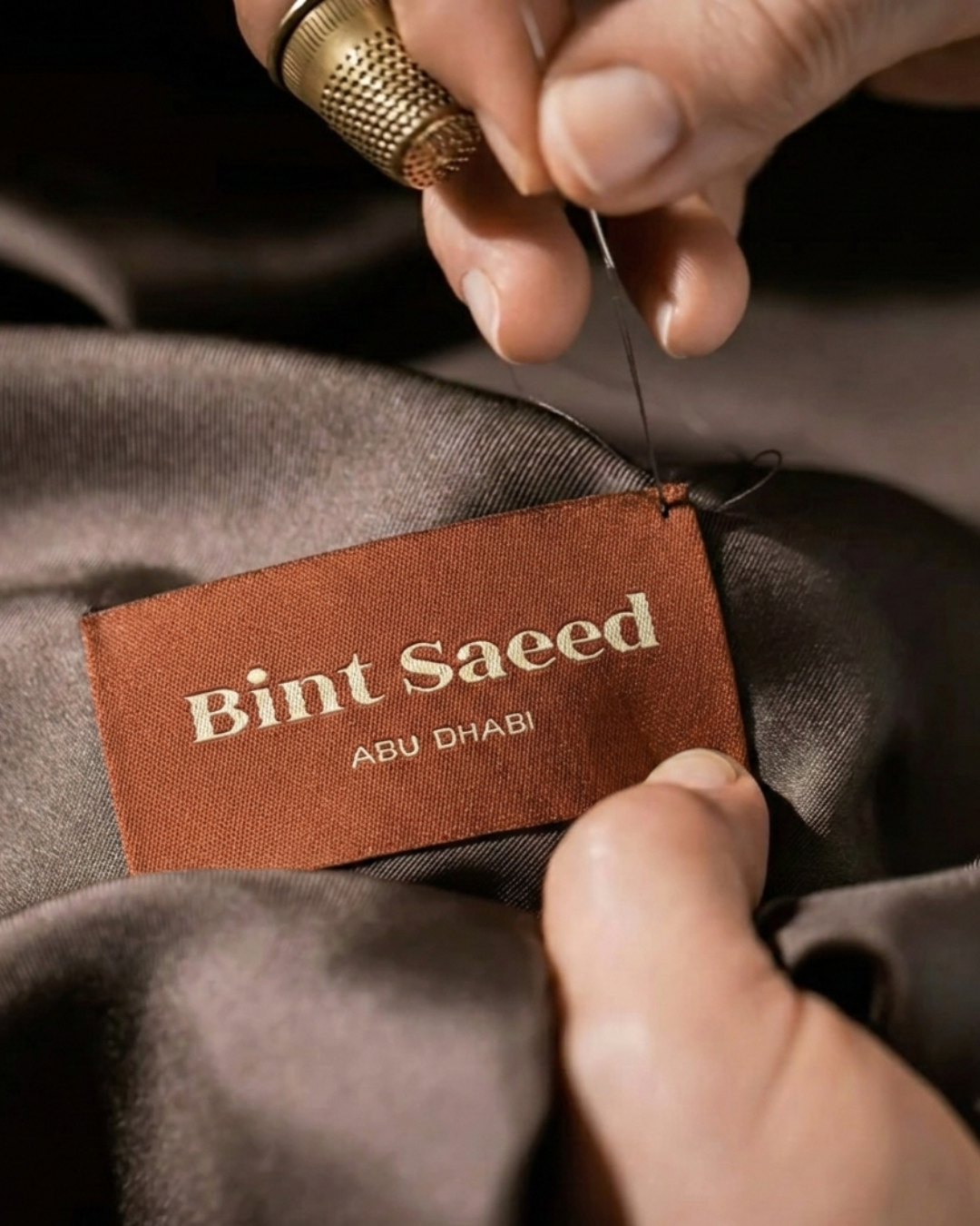 Bint Saeed woven label detail and hand finishing on a bespoke abaya—quality-controlled construction at the Bint Saeed atelier in Abu Dhabi